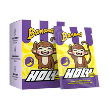 Lila Pappbox mit zwei Bananen-Milchshake-Sachets und einer fröhlichen Affenillustration.